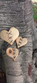 tres Corazón de madera con costura en la mitad y fondo de tronco de madera